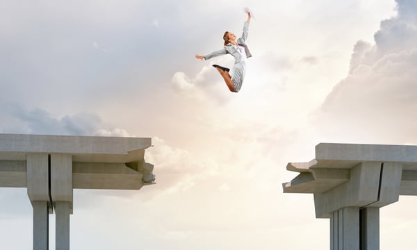 Young woman jumping over a gap in the bridge as a symbol of risk