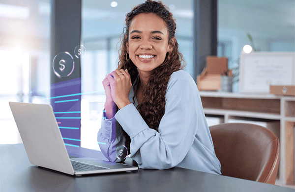 mujer sonriendo sentada frente a laptop en escritorio con graficos financieros alusion a plan de compensacion software