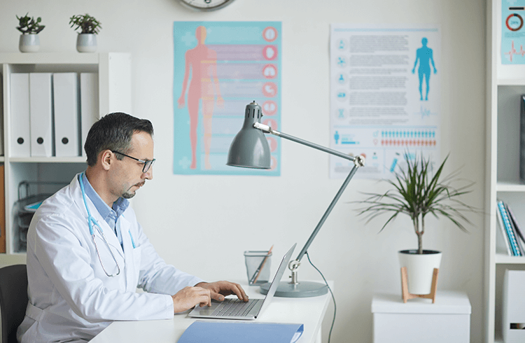 medico usando computador en clinica medica