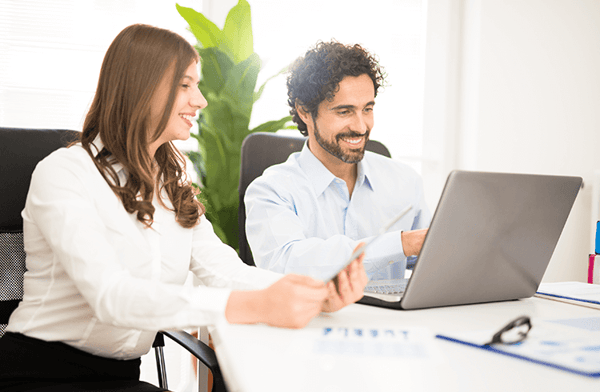 hombre y mujer frente a laptop discutiendo vacaciones de empleados